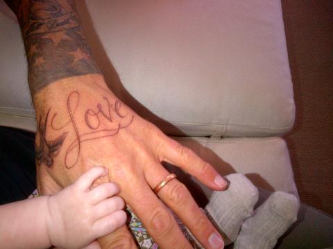 David Beckham's Love tattoo on his hand along with a bird that appears to be 