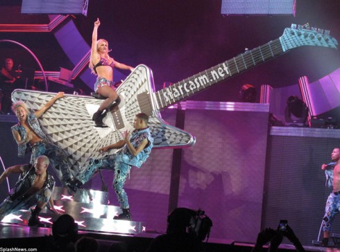 Brit-Brit mounts a giant guitar during the Femme Fatale Tour opener