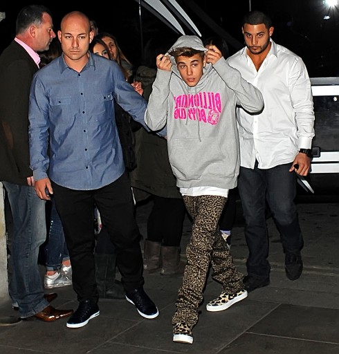 Justin Bieber returns to his London hotel after performing earlier at Capital FM Arena Nottingham. One of Bieber's bodyguards is spotted pointing a flashlight at photographers.